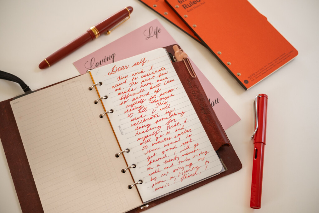 A PLOTTER Leather Binder open to a self-written letter, which is about self-care, beside PLOTTER Refill Memo Pads and fountain pens.