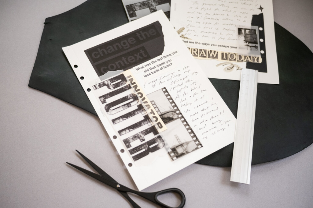 A collage on white paper with black and white graphics and pictures which is on top of a leather mat and a grey table.