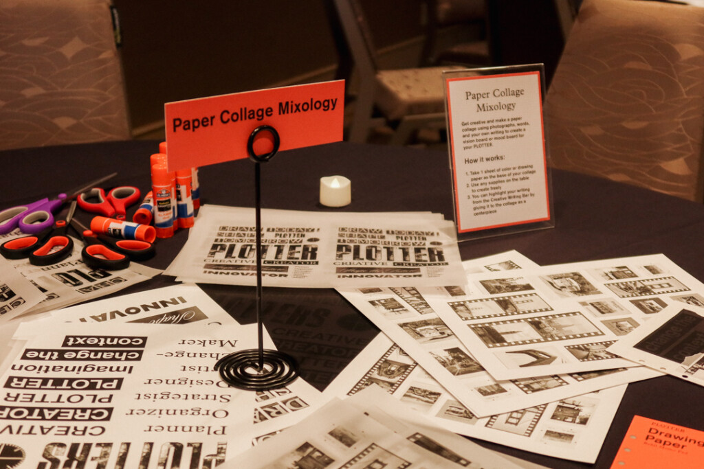 A round table with a black tablecloth with different collage materials, papers, and ephemera on it.