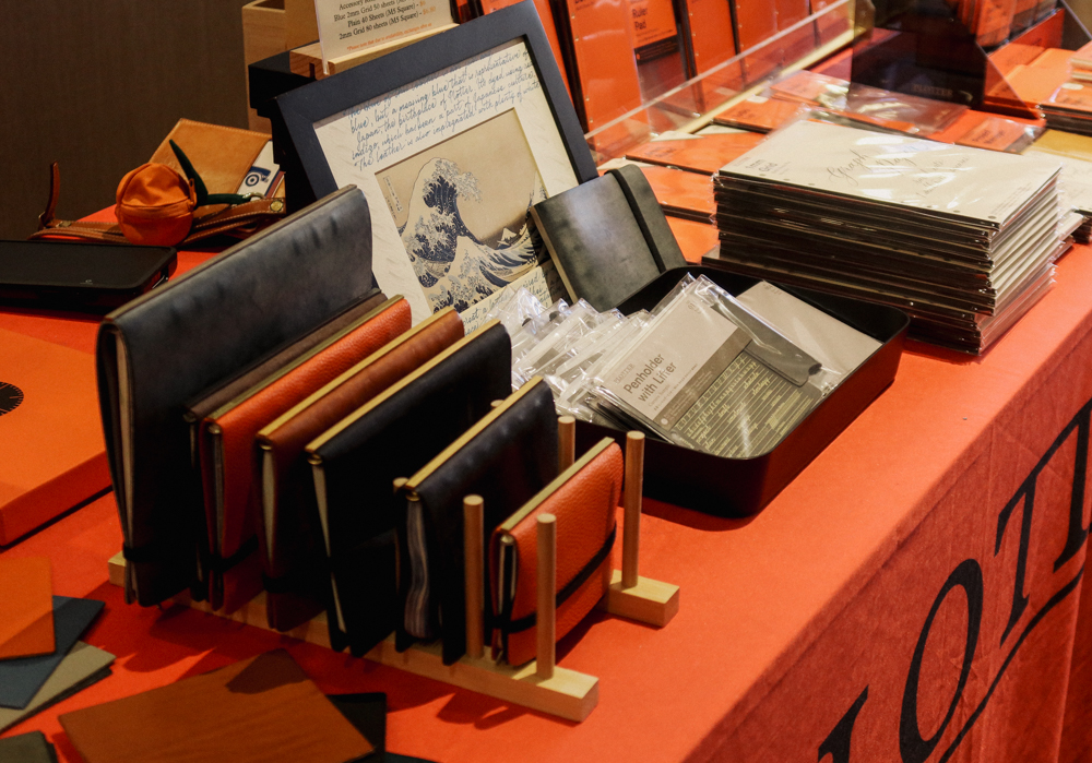A close-up of the PLOTTER USA table showcasing the event-limited and PLOTTER USA-exclusive leather binders.