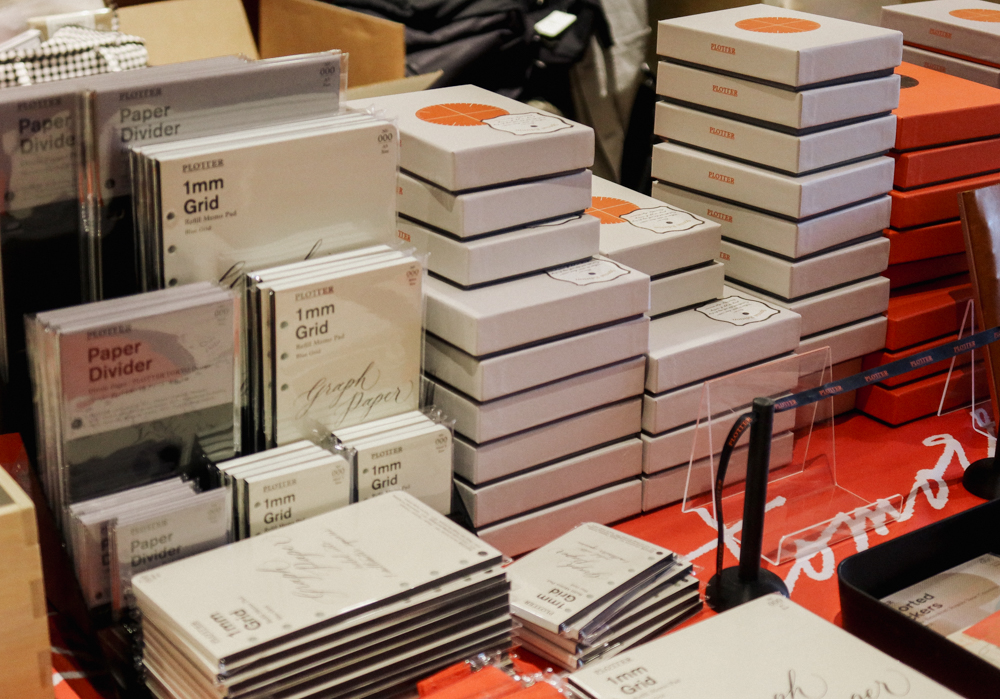 Stacks of grey PLOTTER boxes filled with Leather Binders in various sizes.