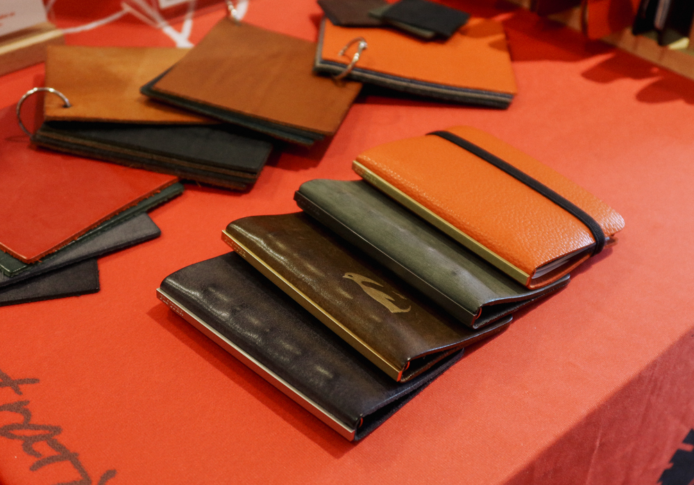 PLOTTER USA table filled with PLOTTER items, leather binders, and stationery at San Francisco Stationery Fest.