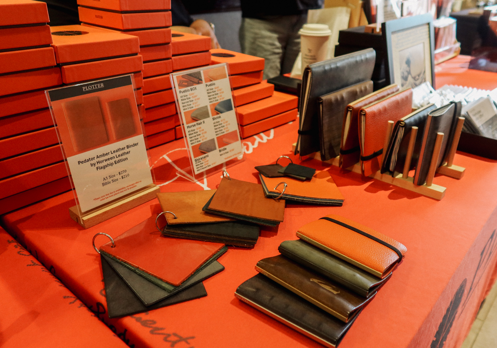 PLOTTER USA table filled with PLOTTER items, leather binders, and stationery at San Francisco Stationery Fest.