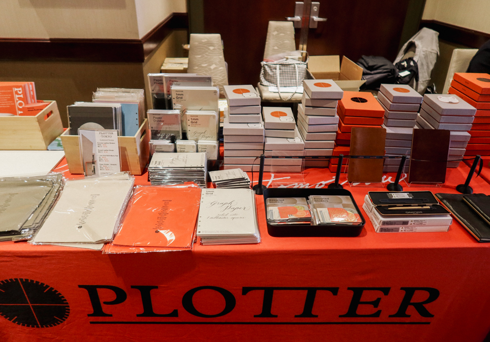 PLOTTER USA table filled with PLOTTER items, leather binders, and stationery at San Francisco Stationery Fest.