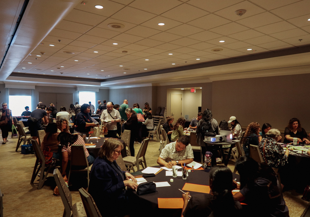 A hotel ballroom filled with guests that are trying out different activities for the PLOTTER Lounge event.