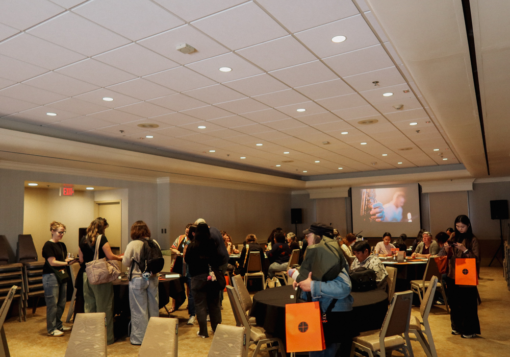A hotel ballroom filled with guests that are trying out different activities for the PLOTTER Lounge event.