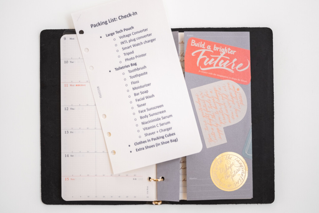 A page of notes resting on top of an open PLOTTER Leather Binder in Bible size.