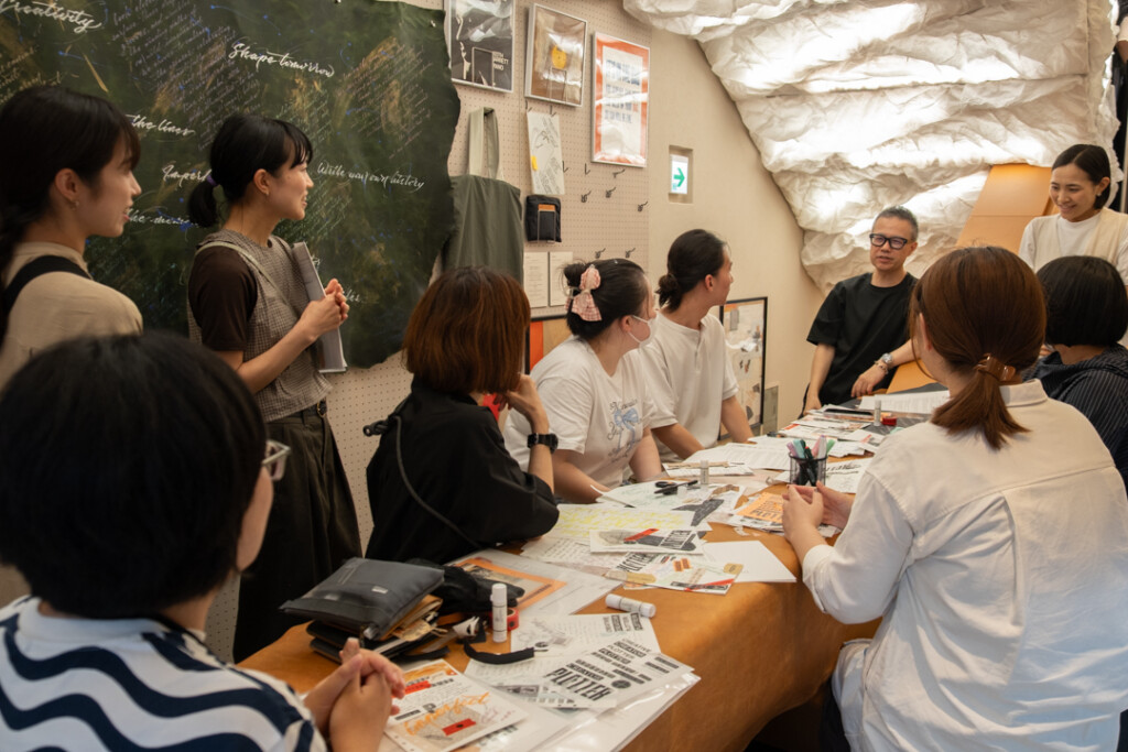 People listening to Takayuki Saito, the Director of PLOTTER, at a workshop in PLOTTER TOKYO store.