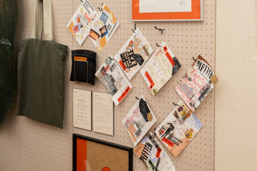 A peg board filled with collages created on PLOTTER Drawing Paper which relate to creativity and use a mixed media approach, which incorporates torn paper, stamps, and calligraphy lettering.