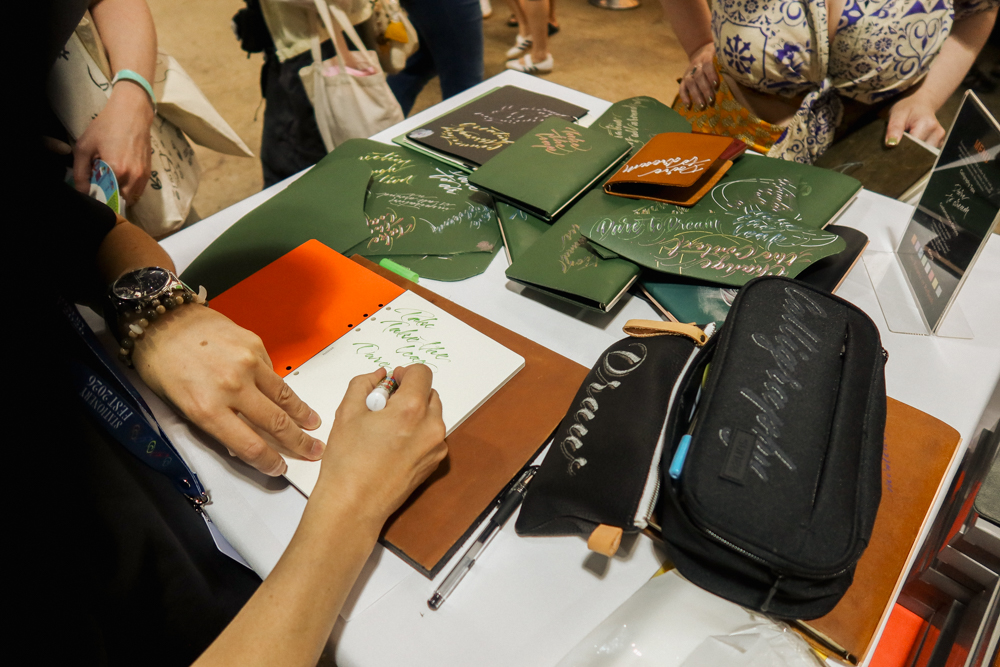 Takayuki Saito, the director of PLOTTER doing hand lettering and calligraphy on PLOTTER leather goods.