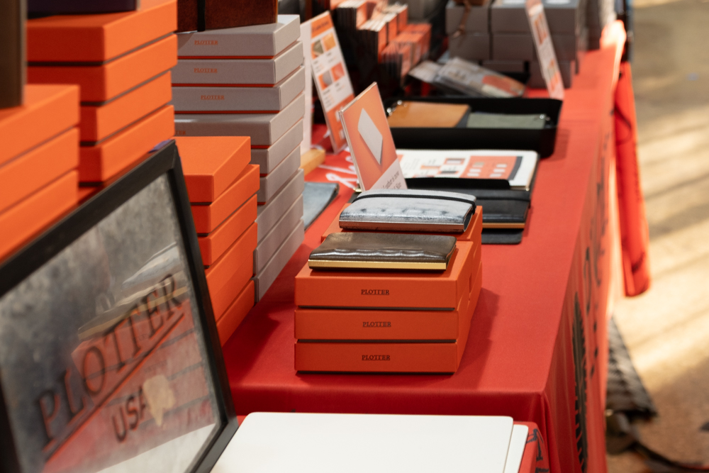 A large stack of PLOTTER boxes with leather binders on top of it.