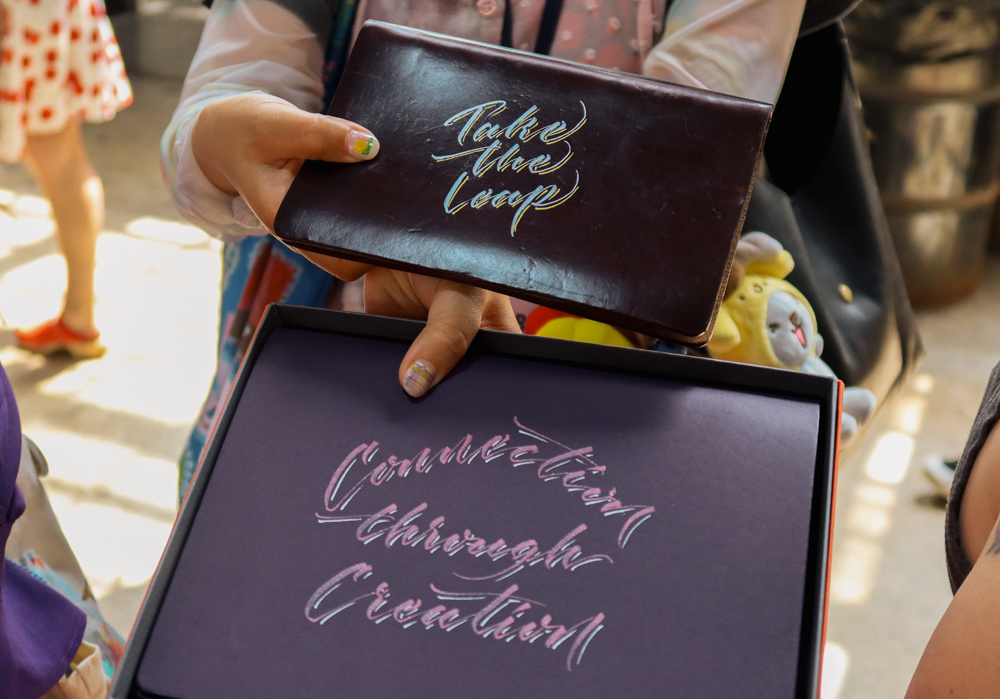 Examples of Takayuki Saito's hand lettering and calligraphy on PLOTTER leather binders.